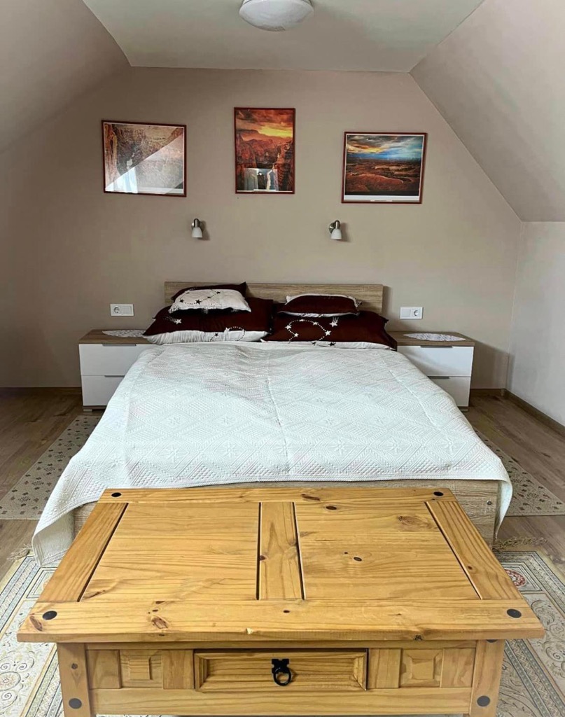 Tetőtéri hálószoba világos fa bútorokkal